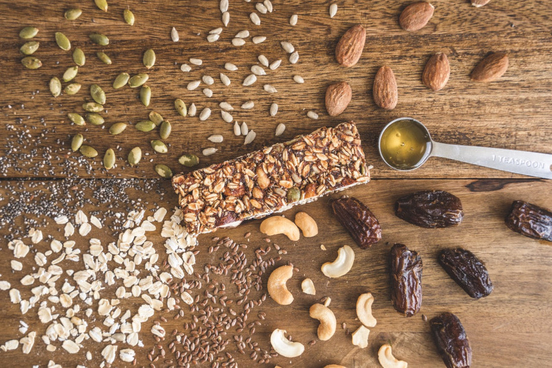 Energy bar with healthy ingredients spread around it.