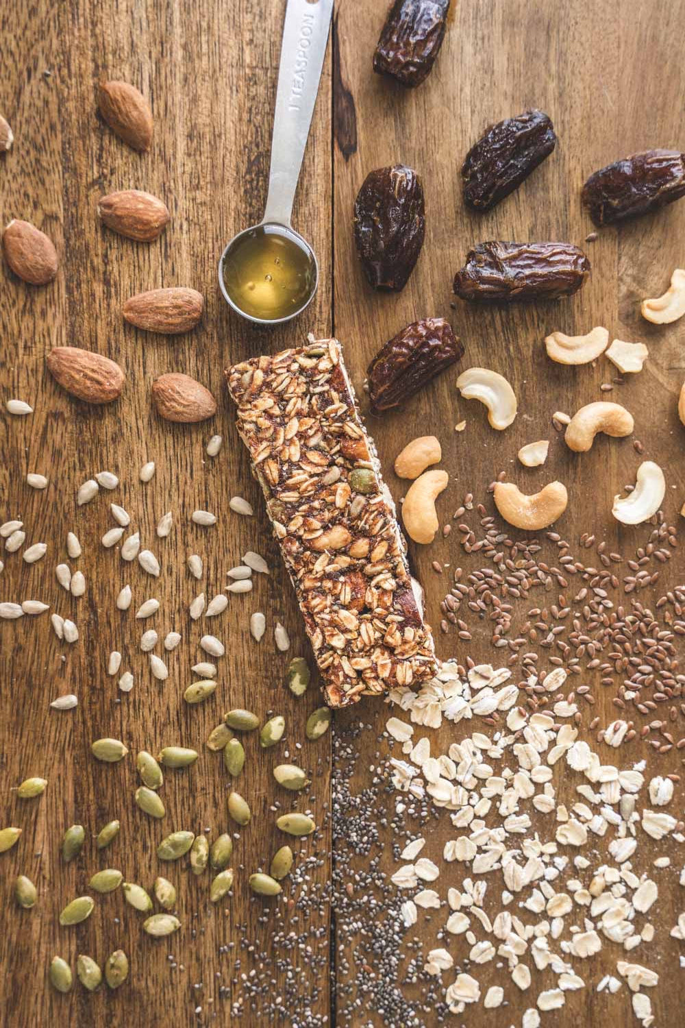 Granola bar with ingredients on a wooden surface
