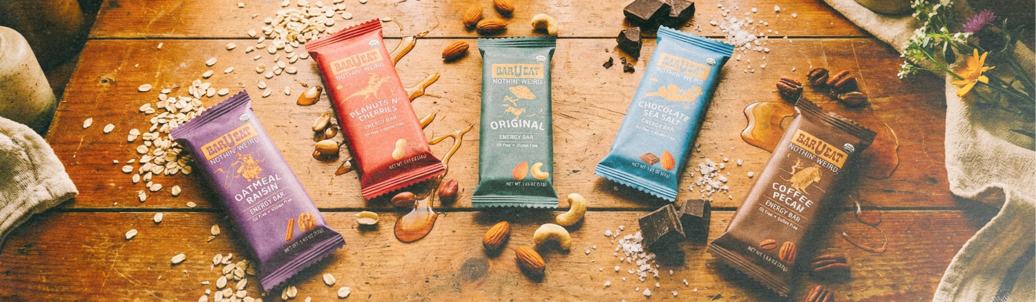 Various barueat energy bars on a wooden table with a soft, natural light background