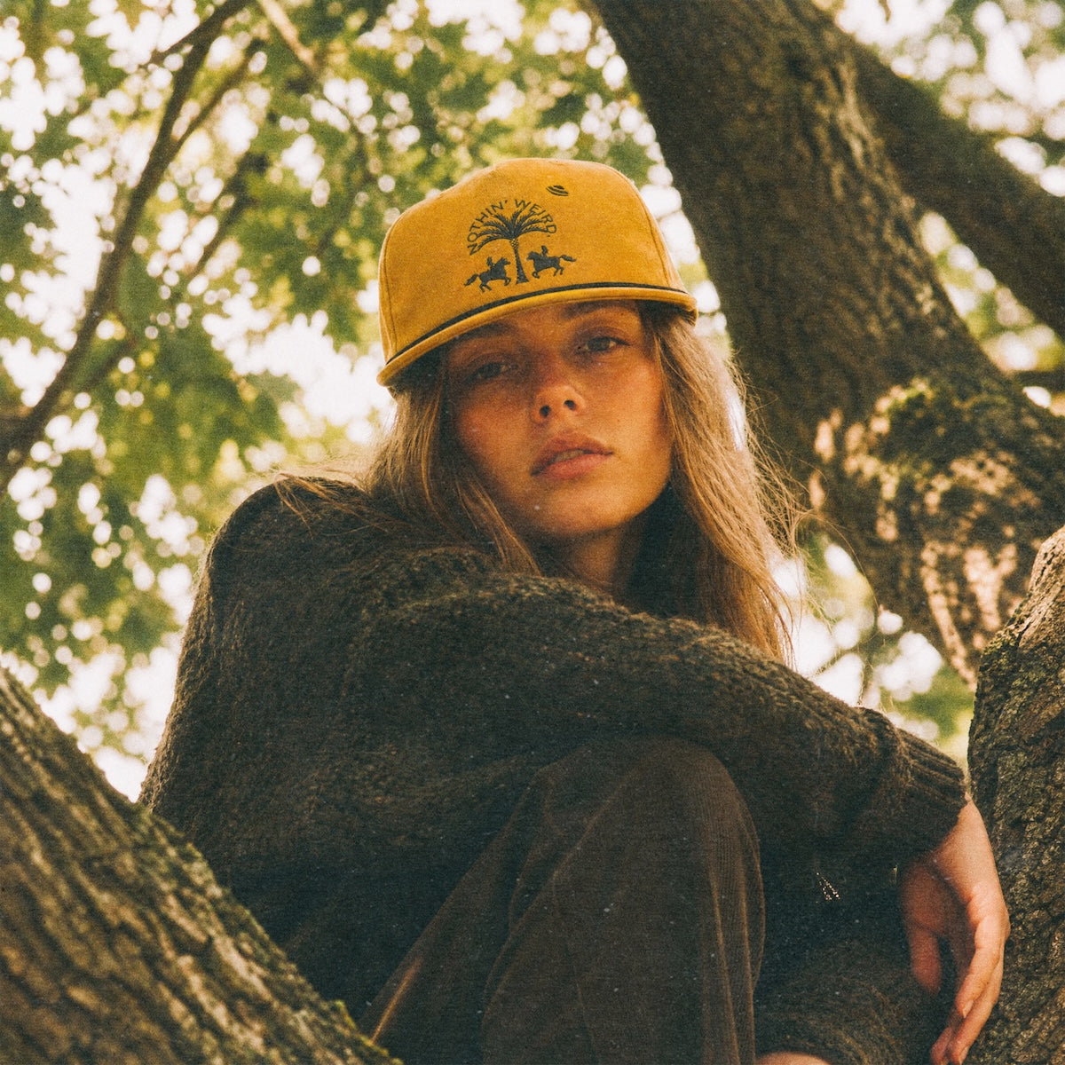 woman wearing the date palm hat in a tree