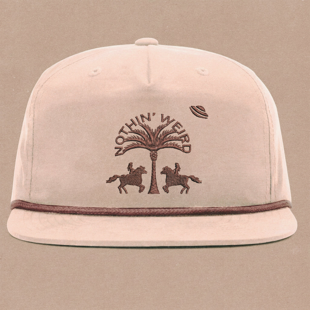 Mauve ball cap with western horses, palm tree, and ufo stitched on it.