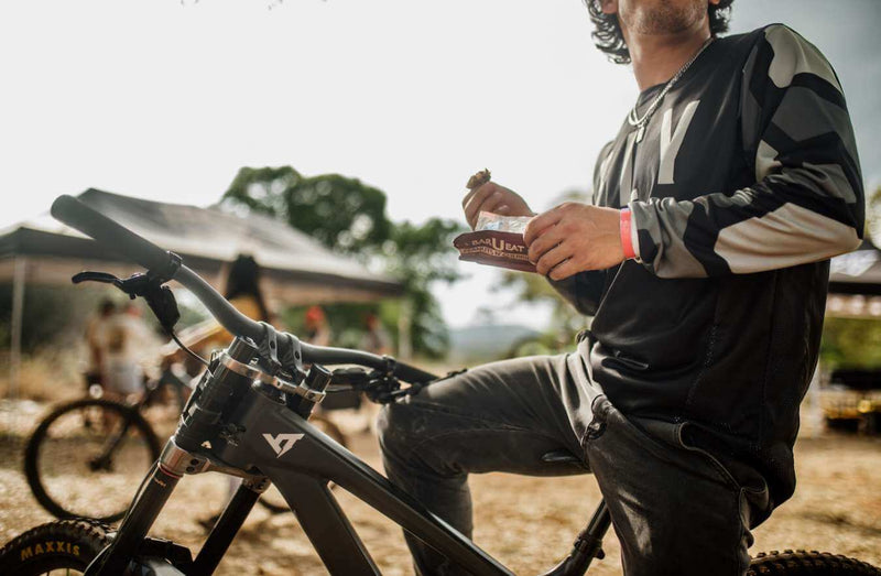 Man eating bar u eat bar while sitting on a mountain bike