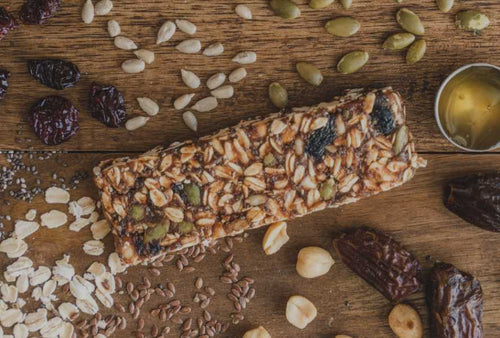 oatmeal raisin bar with ingredients splashed around the bar