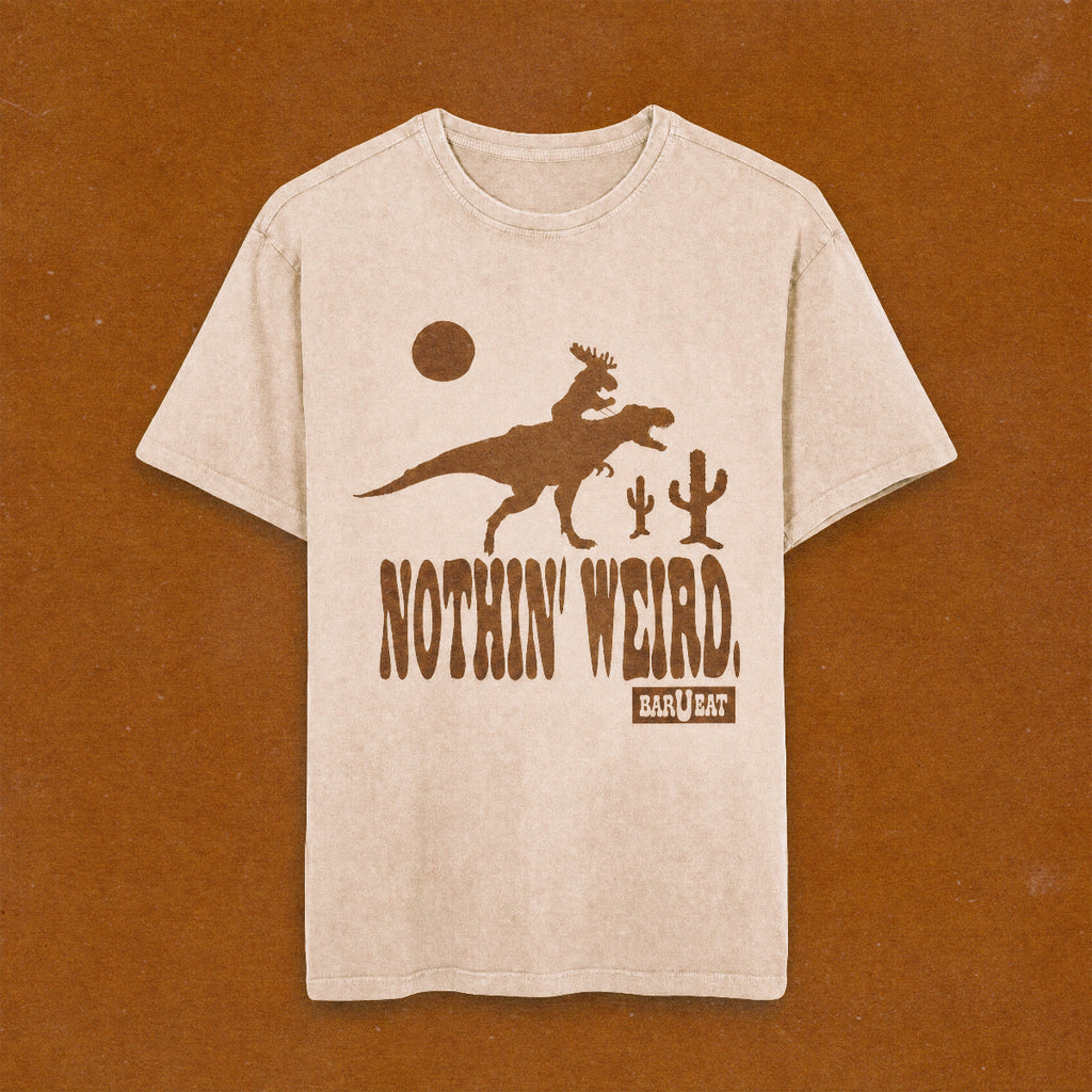 beige t-shirt with moose riding a t-rex with Nothin' Weird text underneath