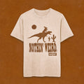 beige t-shirt with moose riding a t-rex with Nothin' Weird text underneath