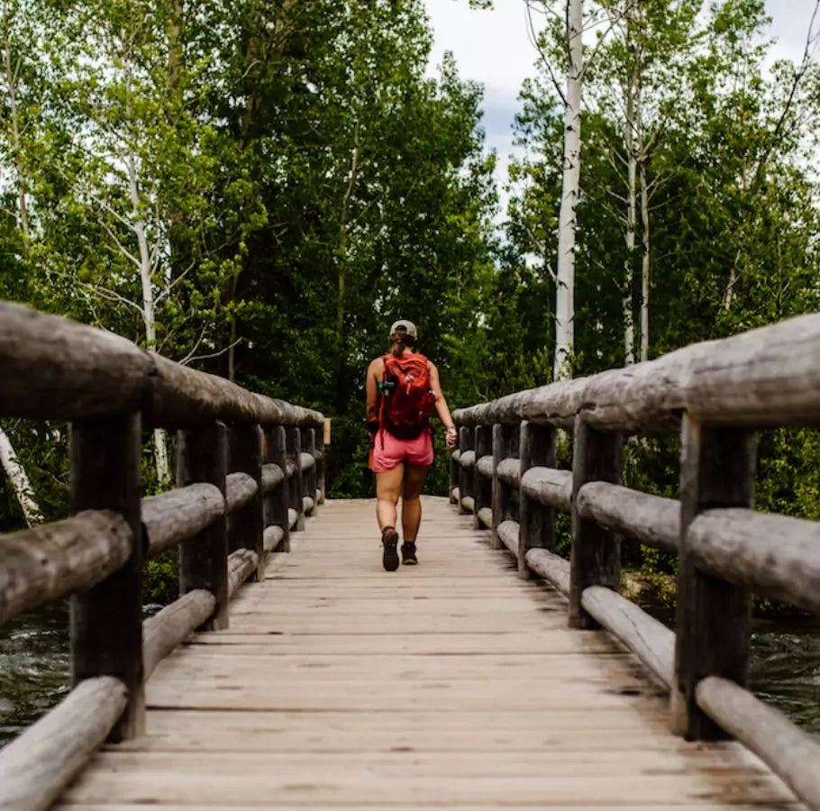 Woman hiking on a wood bridge